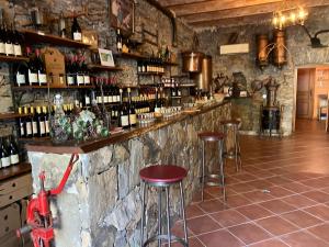 een bar met krukken en flessen wijn bij Hotel Du Vignoble in Patrimonio