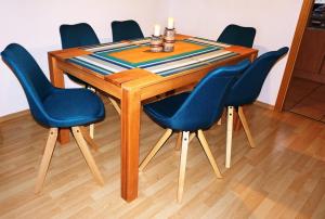 a wooden table with four blue chairs around it at Lechbruck am See Feriendorf Hochbergle Haus 142 - Lechseeblick in Lechbruck +26 photos