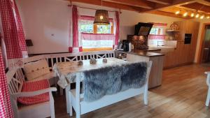 Lechbruck am See Feriendorf Via Claudia Haus 65 Casa Bavaria في ليتشبروك: مطبخ مع طاولة وطاولة وكراسي