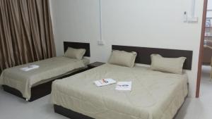 a bedroom with two beds with towels on them at Happy homestay in Teluk Intan