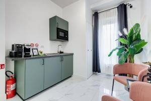 a kitchen with a green cabinet and a window at DIDAVI' Guest House in Rome