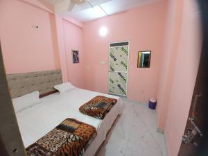 2 camas en una habitación con paredes rosas en Swastik home, en Ujjain