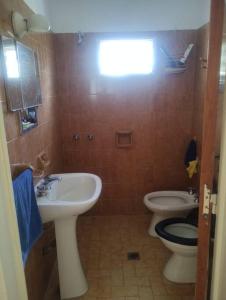 a bathroom with a sink and a toilet at Encantadora Casa con parque in La Falda