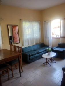 a living room with a blue couch and a table at Encantadora Casa con parque in La Falda