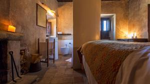 1 dormitorio con 1 cama y baño con bañera en Sextantio Albergo Diffuso, en Santo Stefano di Sessanio