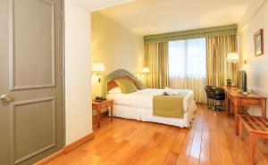 a hotel room with a bed and a desk and a window at Hotel Frontera Clásico in Temuco +45 photos