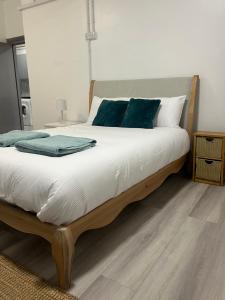 a bedroom with a large bed with blue pillows at En-suite room in Swansea