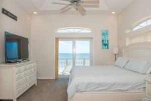 Un dormitorio blanco con una cama y un televisor. en Oceanfront Perfection - 5 Bedroom Private Paradise, en Ponte Vedra Beach