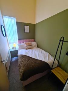 a bedroom with a bed in a green wall at 3 Bed House Etihad in Manchester