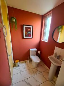 a bathroom with a toilet and a sink at 3 Bed House Etihad in Manchester +12 photos