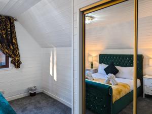 Un dormitorio con una cama verde con dos ositos de peluche. en Morrigan 7-Hot Tub-Pet Friendly-Boutique-Perthshire-Families en Perth