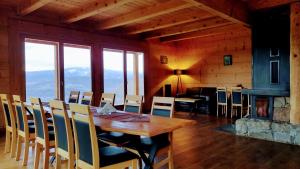 a dining room with a table and chairs and a fireplace at Villa Beskid in Milówka