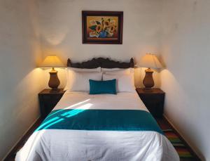 UbatéにあるAlojamiento Rural San Antonioのベッドルーム1室(大型ベッド1台、ランプ2つ付)