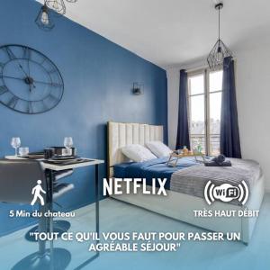 ein Schlafzimmer mit einer blauen Wand mit einer Uhr an der Wand in der Unterkunft Guest loc-Le Saphir-3min château in Versailles