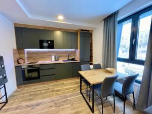 a kitchen and dining room with a table and chairs at Sky Lux Apartments in Jahorina