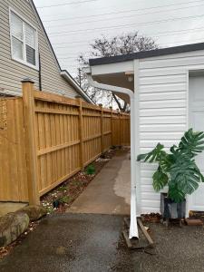 a wooden fence next to a house with a driveway at Njoukwe Empire Suite in Burlington