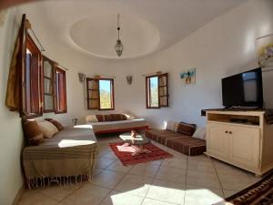 a living room with a couch and a flat screen tv at Menzel Caja in Aghīr