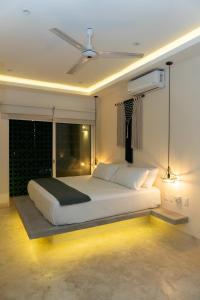 a bedroom with a large white bed with a window at Kanté Hotel - Downtown Tulum in Tulum +58 photos