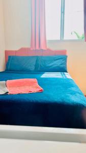 a blue bed with a red towel on it at Apartamento ACOMODA 5 PESSOAS próximo ao Uberlândia Shopping in Uberlândia