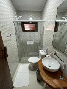 ein Bad mit einem WC, einem Waschbecken und einer Dusche in der Unterkunft Pousada Anjo da Guarda in Guarda do Embaú
