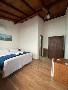 ein Schlafzimmer mit einem großen Bett und Holzboden in der Unterkunft Pousada Anjo da Guarda in Guarda do Embaú