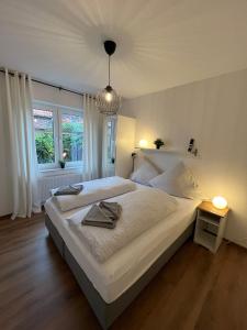 sypialnia z dużym białym łóżkiem i oknem w obiekcie Ostfriesenperle w mieście Aurich