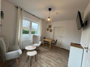 a living room with a table and chairs and a window at Ostfriesenperle in Aurich