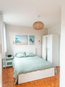 塞納河畔伊夫里的住宿－Suite familiale à Paris，白色卧室配有一张床和一个吊灯