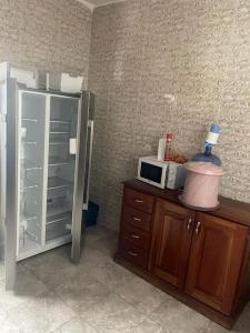 eine Küche mit einem Kühlschrank und einer Mikrowelle auf der Theke in der Unterkunft Spacieux F4 confort et modernité in Dakar