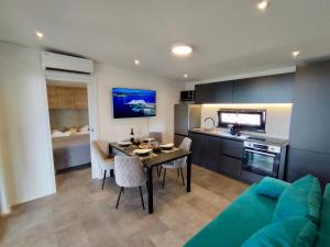 uma cozinha e sala de estar com uma mesa e um sofá em Luxury Mobile Home Kasthouse Oleander em Mali Lošinj