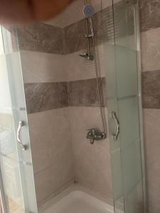 a shower with a glass door in a bathroom at Spacieux F4 confort et modernité in Dakar
