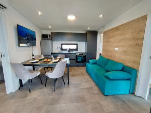 a living room with a blue couch and a table at Luxury Mobile Home Kasthouse Oleander in Mali Lošinj