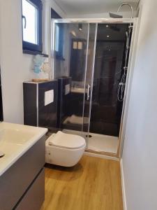 a bathroom with a toilet and a glass shower at Luxury Mobile Home Kasthouse Oleander in Mali Lošinj