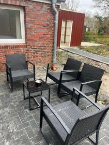 patio z 3 krzesłami i stołem oraz ceglany budynek w obiekcie Ostfriesenperle w mieście Aurich