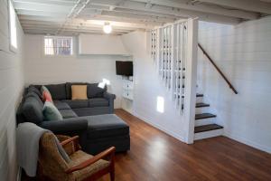 ein Wohnzimmer mit einem Sofa und einer Treppe in der Unterkunft Beautiful Ranch Style Home - Minutes from Downtown CVille! in Charlottesville