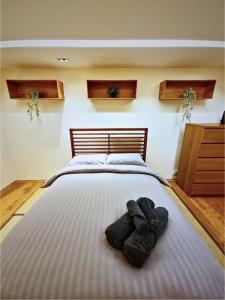 Un dormitorio con una cama grande con dos pares de zapatos. en Wood studio flat, en Londres