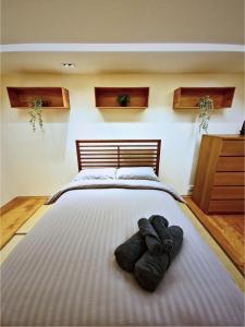 a bedroom with a large bed with two pairs of shoes on it at Wood studio flat in London