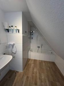 W łazience znajduje się umywalka i wanna. w obiekcie Ostfriesenperle w mieście Aurich