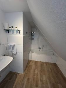 a bathroom with a sink and a bath tub at Ostfriesenperle in Aurich +10 photos