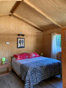 um quarto com uma cama com um edredão azul em Cabañas Roka Caburgua em Pucón