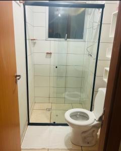 La salle de bains est pourvue de toilettes et d'une douche en verre. dans l'établissement Apartamento ACOMODA 5 PESSOAS próximo ao Uberlândia Shopping, à Uberlândia