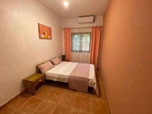 a small bedroom with a bed and a window at Tropical House in Pamandzi