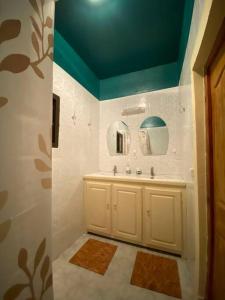 a bathroom with a sink and a blue ceiling at Tropical House in Pamandzi