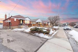 a house on a street with snow on the ground at 2 Bedroom East-York bungalow in Toronto