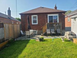 a backyard with chairs and an umbrella on a deck at 2 Bedroom East-York bungalow in Toronto
