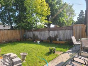 a backyard with a fence and a table and chairs at 2 Bedroom East-York bungalow in Toronto