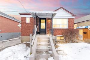 a brick house with a front door in the snow at 2 Bedroom East-York bungalow in Toronto