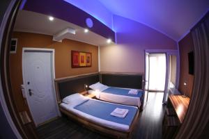 two beds in a room with purple lighting at Apartments 43 in Krnjača