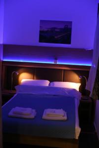a bedroom with a bed with a blue lighting at Apartments 43 in Krnjača