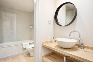 a bathroom with a sink and a toilet and a mirror at Luderna - Apartamento con terraza Bonaigua B1 Joanchiquet in Baqueira-Beret